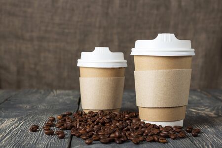 Two cup-with hot drink, coffee beans on old wooden tableの写真素材
