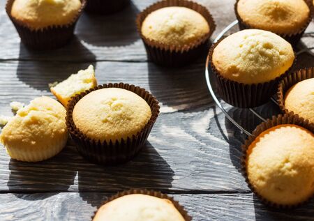 Fragrant vanilla cupcakes in molds on gray wooden surfaceの写真素材