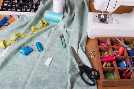 Sewing machine and cloth, set of sewing accessories on work tableの写真素材