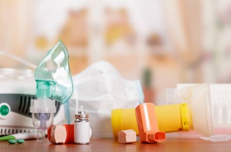 Three types of inhalers - mesh nebulizer, a compressor and a small portable on wooden tableの写真素材