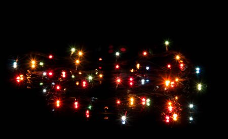 Glittering lights Christmas garland isolated on black backgroundの写真素材