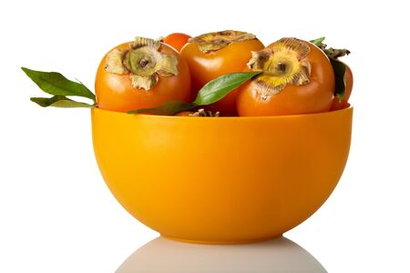 Full bowl of bright orange persimmon fruit isolated on white backgroundの写真素材