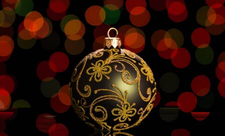 Beautiful green Christmas ball with patterns, on dark shimmering backgroundの写真素材