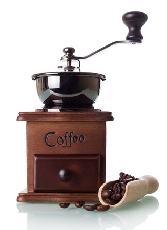 Manual coffee grinder with a box for ground powder, near scoop with coffee beans, isolated on white backgroundの写真素材