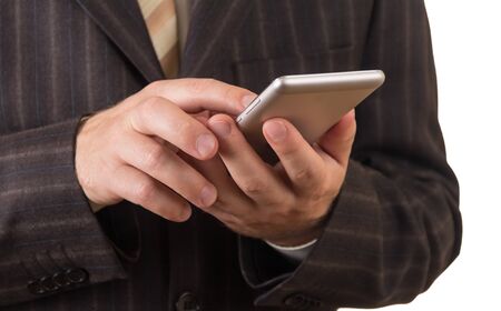 Business man in suit with smartphone isolated on white backgroundの写真素材