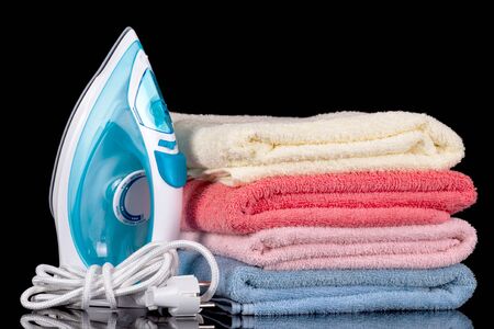 Steam iron and cotton towels isolated on black background.の写真素材