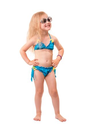 A smiling little blond girl in a swimsuit isolated on white background.の写真素材