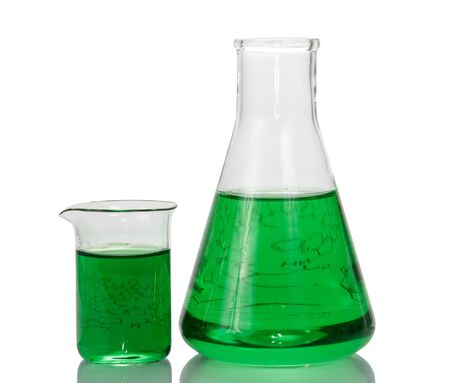 A chemical flask, a beaker with green liquids and a sheet of paper with formulas isolated on a white background.の写真素材