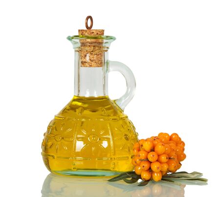 Branch with berries of sea-buckthorn and bottle of oil close-up isolated on white background.の写真素材