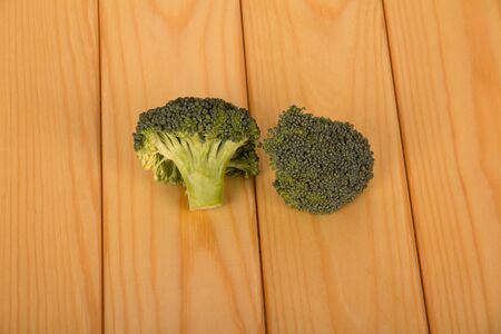 Ripe inflorescences of broccoli on a light wood background.の写真素材