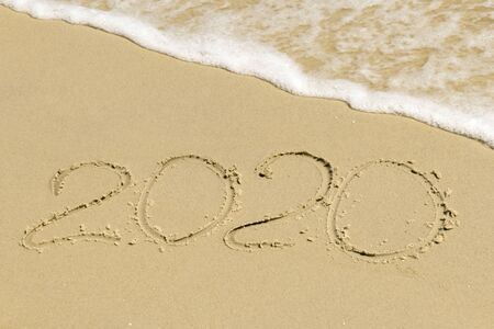 2020 inscription on sand with sea foam of the seaの写真素材