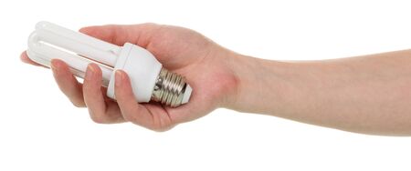 In a female hand a compact fluorescent light bulb is isolated on a white background.の写真素材