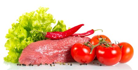 Piece of raw beef, tomato, lettuce, red and black pepper isolated on white background.の写真素材