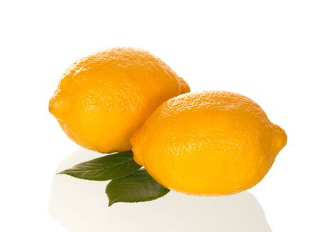 Two bright yellow lemons with leaves isolated on white backgroundの写真素材