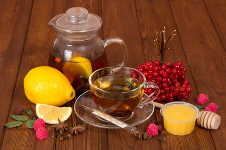Hot tea with honey and medicinal plants from colds, against background of wooden tableの写真素材