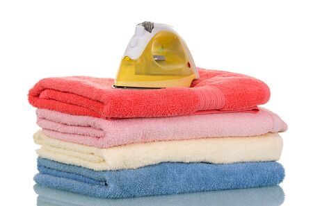 The pile of clean terry towels and device for ironing isolated on white background  の写真素材