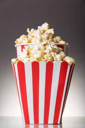 Two striped boxes filled with popcorn on gray backgroundの写真素材