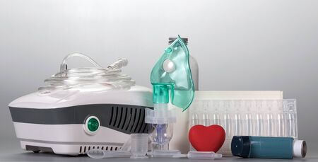 Portable and Compressor inhaler whis mask, dosage medication on gray backgroundの写真素材