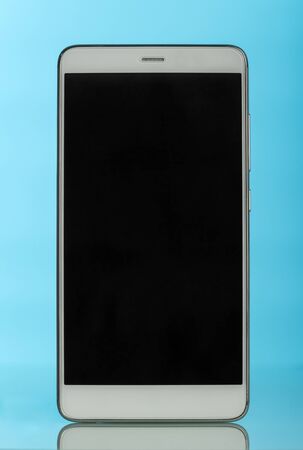 A modern smartphone with a touch screen on blue background.の写真素材