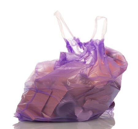 Lilac polyethylene bag with handles, filled with garbage isolated on white background.の写真素材