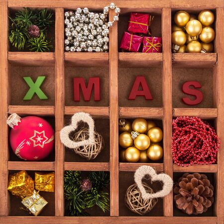 A set of Christmas decorations in a wooden box with cells and the inscription Xmas. Backgroundの写真素材