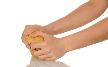 Female hands kneading piece of dough, isolated on white backgroundの写真素材