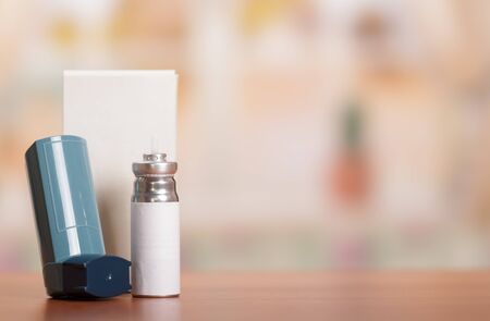 Device for inhalation, a spare vial of medicine, on  background of tableの写真素材