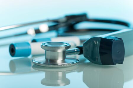 Small pocket inhaler, phonendoscope and test tubes on blue backgroundの写真素材