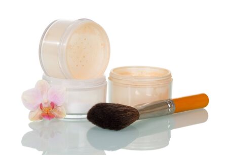 Empty open jars of powder, cosmetic brush and orchid flower isolated on white background.の写真素材