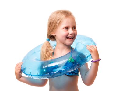 A smiling little blond girl in a swimsuit isolated on white background.の写真素材