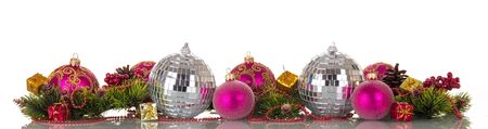 Bright christmas-tree toys with sparkles, beads and pine branches beautifully stripped, isolated on white backgroundの写真素材