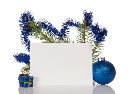 Pine branches decorated with tinsel, small Christmas gift and toy, blank card, isolated on white backgroundの写真素材