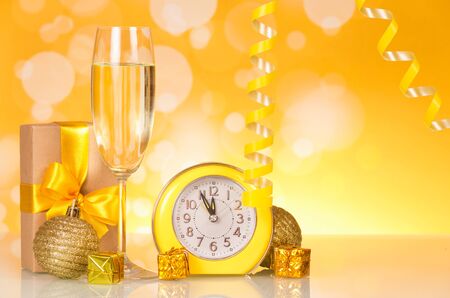 Waiting for the new year, watch, gifts, champagne, on bright yellow backgroundの写真素材