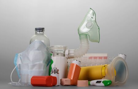 Modern electronic mesh-nebulizer small portable inhaler, vials of liquid for inhalation, on gray backgroundの写真素材