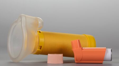 Small pocket inhaler for asthmatics and children's mask, on gray backgroundの写真素材