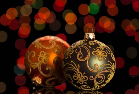 Two bright Christmas balls with patterns, on dark shimmering backgroundの写真素材