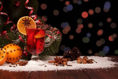 Spicy warming drink, fruits, nuts and spices on shimmering dark backgroundの写真素材
