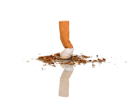 Stub out cigarette, beside scattered tobacco crumbs, isolated on white backgroundの写真素材