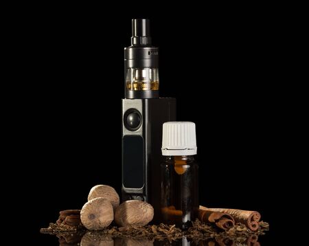 Electronic cigarette and crumbs of tobacco, liquid for smoking, spices isolated on a blackの写真素材