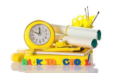 Set of school supplies, an alarm clock and an inscription back to school, isolated on white backgroundの写真素材