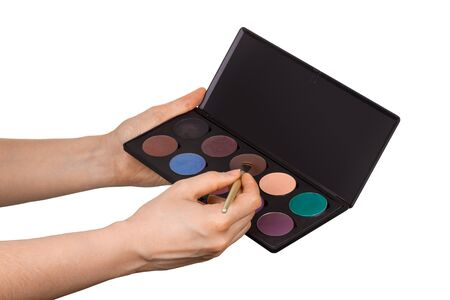 Set of make-up cosmetics for make-up and brush in female hands isolated on white backgroundの写真素材