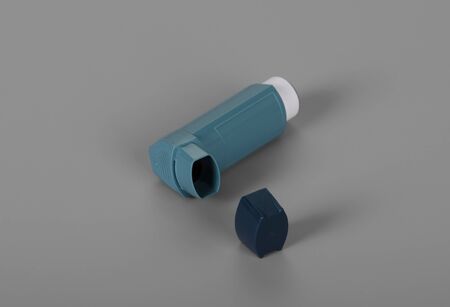 Inhaler dosing for asthmatics, on gray backgroundの写真素材