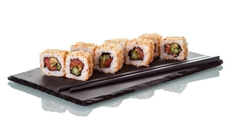 Sushi rolls sprinkled with seeds of sesame and chopsticks, on special stand, isolated on white backgroundの写真素材