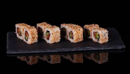 Traditional Asian platter of sushi on special stand, isolated on black backgroundの写真素材