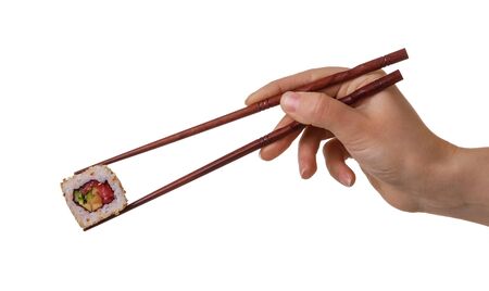 Hand of female keeps sushi rolls with wooden chopsticks isolated on white backgroundの写真素材