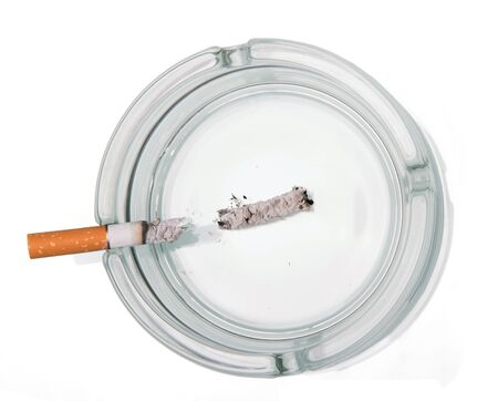 Cigarette butt in glass ashtray isolated on white backgroundの写真素材