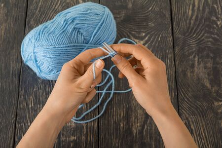Skein of blue yarn and knitting needles. Hand made on dark wooden surfaceの写真素材