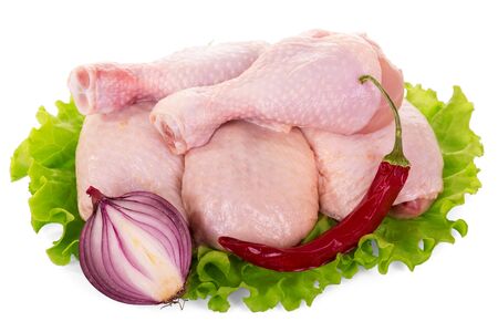 Crude Chicken drumstick on lettuce leaf, near chili pepper and onion isolated on white backgroundの写真素材