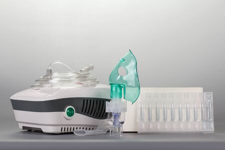 Universal compressor nebulizer and child mask, vials of solution, on gray backgroundの写真素材