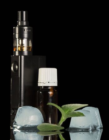 E-cigarette, liquid for smoking, ice cubes and mint isolated on black backgroundの写真素材